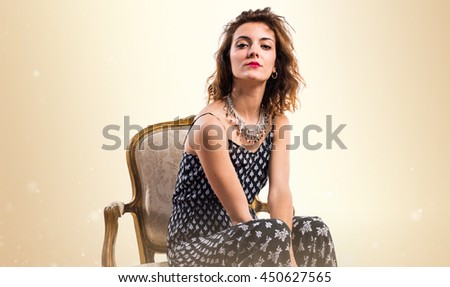 Model woman on vintage armchair over ocher background