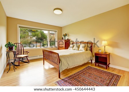 Bedroom with hardwood floor, bright walls and wooden furniture set