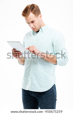 Portrait of a young redhead man using tablet computer isolated on a white background