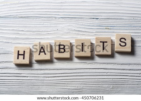HABITS word written on wood abc block at wooden background.