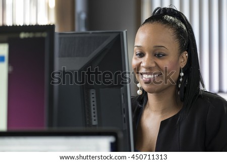 Young woman working on a computer, looking at the monitor