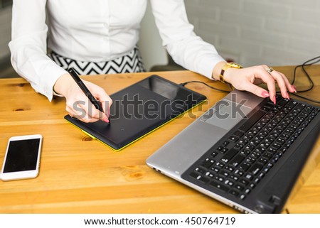 Woman hand drawing with graphics tablet, working designer close-up