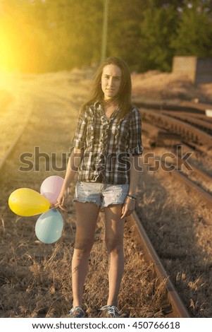 Traveler woman on railway in summer sunset