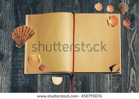 notebook and sea shells on the blue wooden background