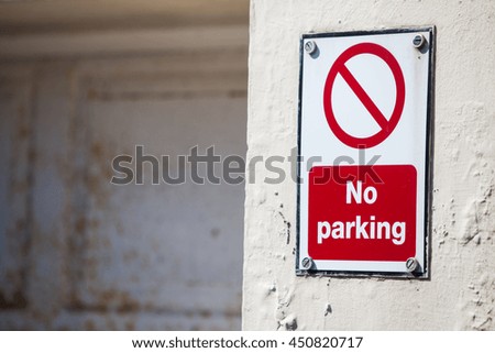 Color image of a No Parking sign on a wall.