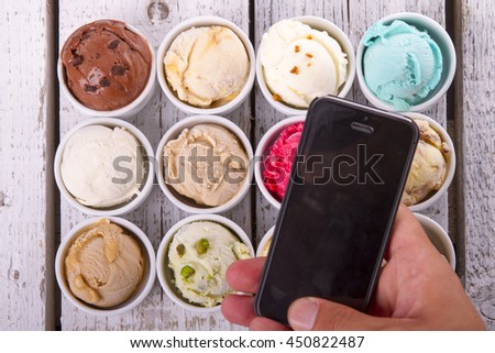 Taking photo of  ice cream on wooden table with smart mobile phone 