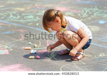 
little girl draws a chalk
 Royalty-Free Stock Photo #450828013