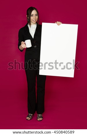 Young business woman holding a white board and a coffee cup against pink background