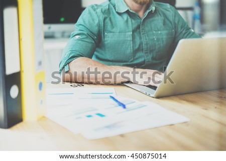 Social Trading Online Public Relations Manger Analyze Reports.Guy working wood table Modern Interior Office.Businessman Work Coworking Studio.Using Digital Laptop.Blurred Background.Business Startup Royalty-Free Stock Photo #450875014