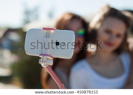 Two happy young girls taking a self portrait, young beautiful ladies having fun together, smiles. summer teenage best friends and friendship holidays outdoors concept. 
