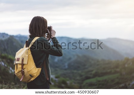 Hipster young girl with backpack taking photo of amazing landscape sunset on vintage camera close on peak of foggy mountain mockup. Tourist traveler on background sunlight in trip, mock up for text. 