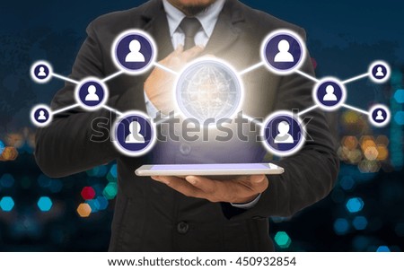 Businessman holding the tablet with the Social media symbol on Blurred Photo bokeh of cityscape, Elements of this image furnished by NASA, Business network concept 