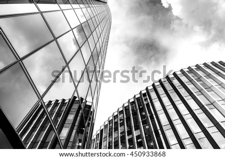 Black and white image of steel and glass skyscrapers of London against a cloudy sky