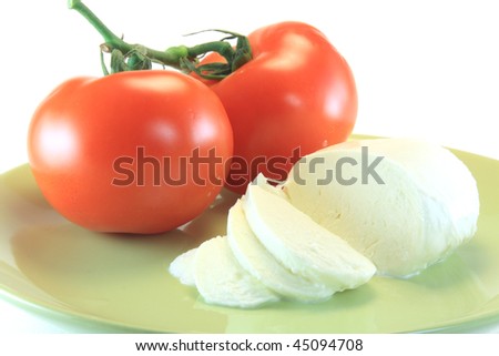 slice of mozzarella and tomato in green plate isolated on white