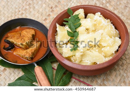 Top view of spicy hot king/barracuda fish curry with cooked tapioca/cassava root in mud/clay pot, Kerala India.made with green chilli, coconut milk and mango Asian cuisine. South Indian food sea food.