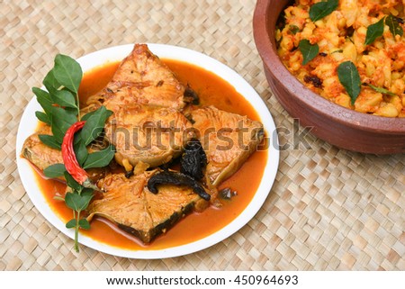 Top view of spicy hot king/barracuda fish curry with cooked tapioca/cassava root in porcelain plate, Kerala India.made with green chilli, coconut milk, mango Asian cuisine. South Indian food sea food.