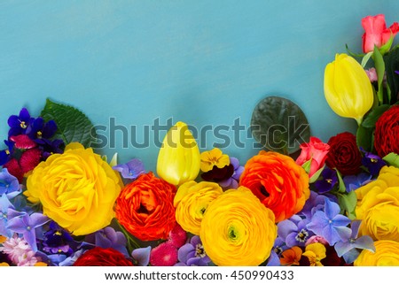 Flowers fresh festive border composition on blue wooden table background with copy space