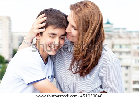 Portrait of a mother with her son teenager. Tenderness, love, multinational family Royalty-Free Stock Photo #451039048