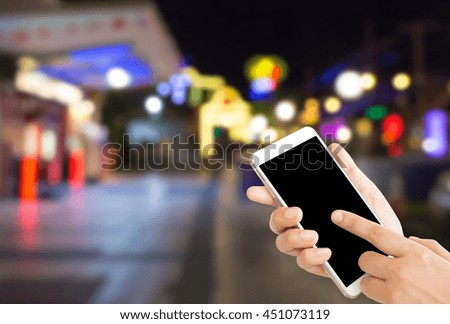 woman use mobile phone and blurred image of night restaurant with beautiful bokeh from the lights,beautiful night club