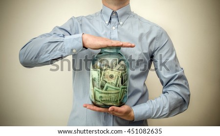 man holding a jar full of money 