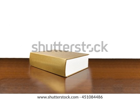 Golden book on wooden table isolated on white background