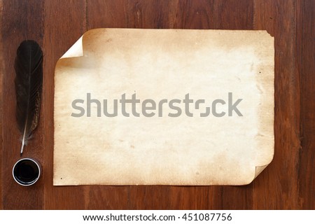 old paper with feather and ink on wooden background