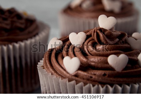 Multiple chocolate nicely decorated muffins on a wooden background