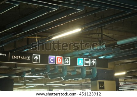 Sign lighting underground parking lot, still low light.