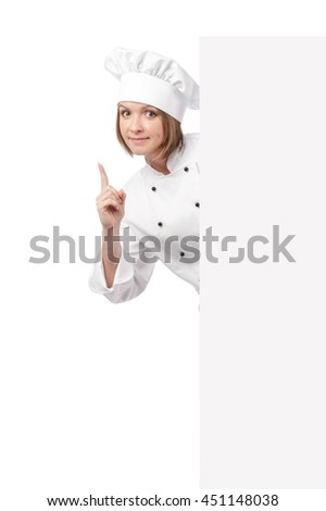 smiling female chef, cook or baker pointing up and hiding behind banner with empty copy space for you text isolated on white background. advertisement blank board. your text here