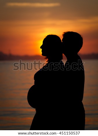 Pregnant couple during the sunset
