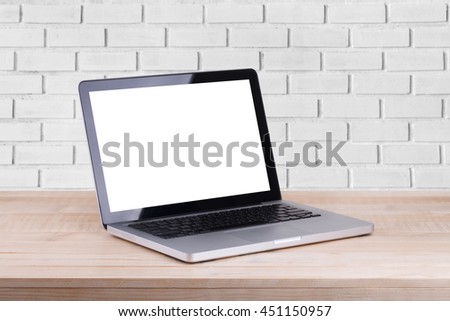 Front view of the laptop is on the work table brick background
