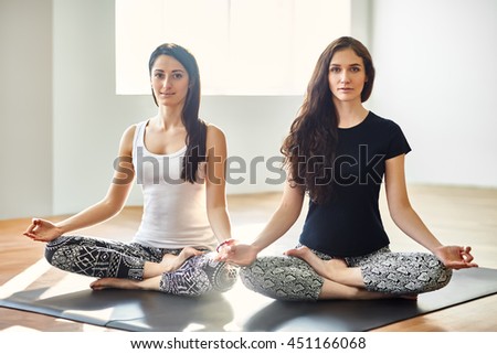 Two young women meditating in Lotus Pose. Padmasan