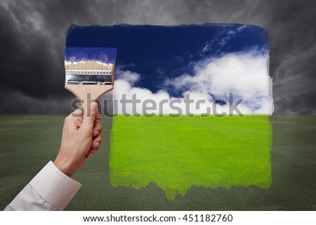 Man hand holding painting brush, paint bright day with blue sky and white cloud on green grass field replace bad cloudy day. Conceptual illustration of new better world or optimistic vision. Royalty-Free Stock Photo #451182760