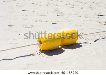 Two buoys in the sand on a beach