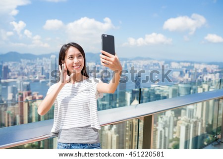 Woman using mobile phone to take photo in Hong Kong