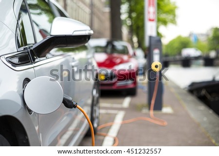 Charging an electric car - ecological way of driving Royalty-Free Stock Photo #451232557