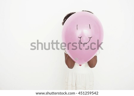 Girl blowing up balloon with smiley face