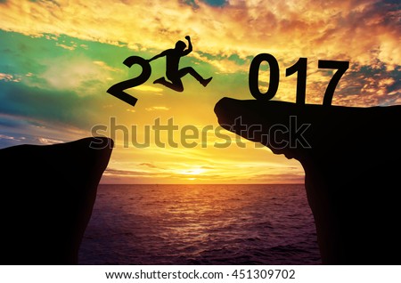 A man hold number 2 jump between hill 2017 years, success concept, Silhouette. Royalty-Free Stock Photo #451309702
