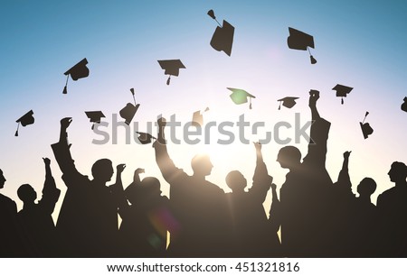 education, graduation and people concept - silhouettes of many happy students in gowns throwing mortarboards in air Royalty-Free Stock Photo #451321816