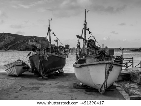 Fishing boats on the shore of Lulworth cove on the Jurassic coast of Dorset in Black and White 