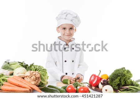 One little boy as chef cook making salad, cooking with vegetables. Isolated on white.