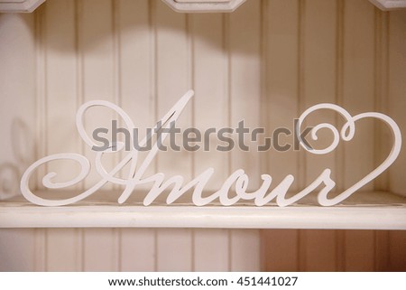 White wooden lettering Amour stands on the book shelve