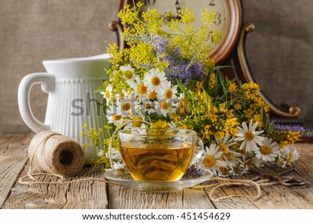 Chamomile tea on wooden kitchen table, relax evening concept