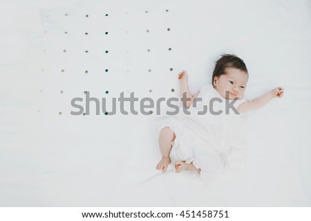 little baby lying on a white canvas