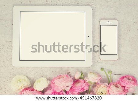 Pink and white ranunculus flowers styled flat lay scene with tablet and mobile, retro toned