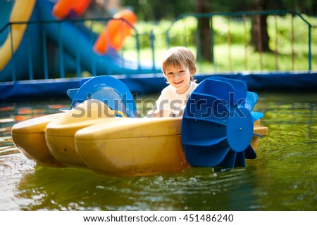small child rides on a small catamaran in the pool Royalty-Free Stock Photo #451486240