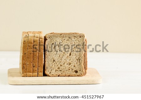 A sliced loaf of sprouted grain and seed bread on a cutting board. Royalty-Free Stock Photo #451527967