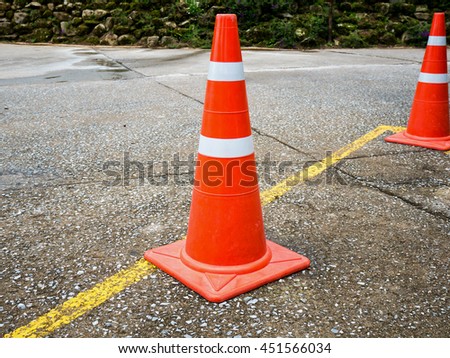 Traffic cone on the asphalt road with yellow line
