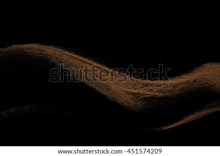 Sandy wave isolated on black background. Abstract sand explosion. Grainy texture.