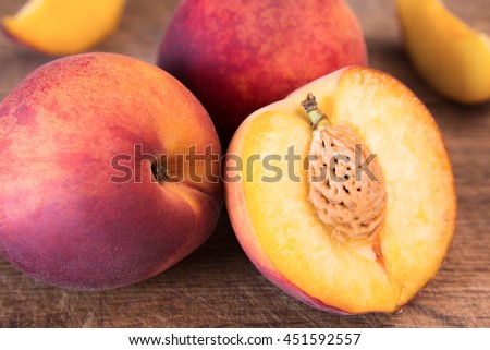 Fresh peaches on a wooden cutting board.